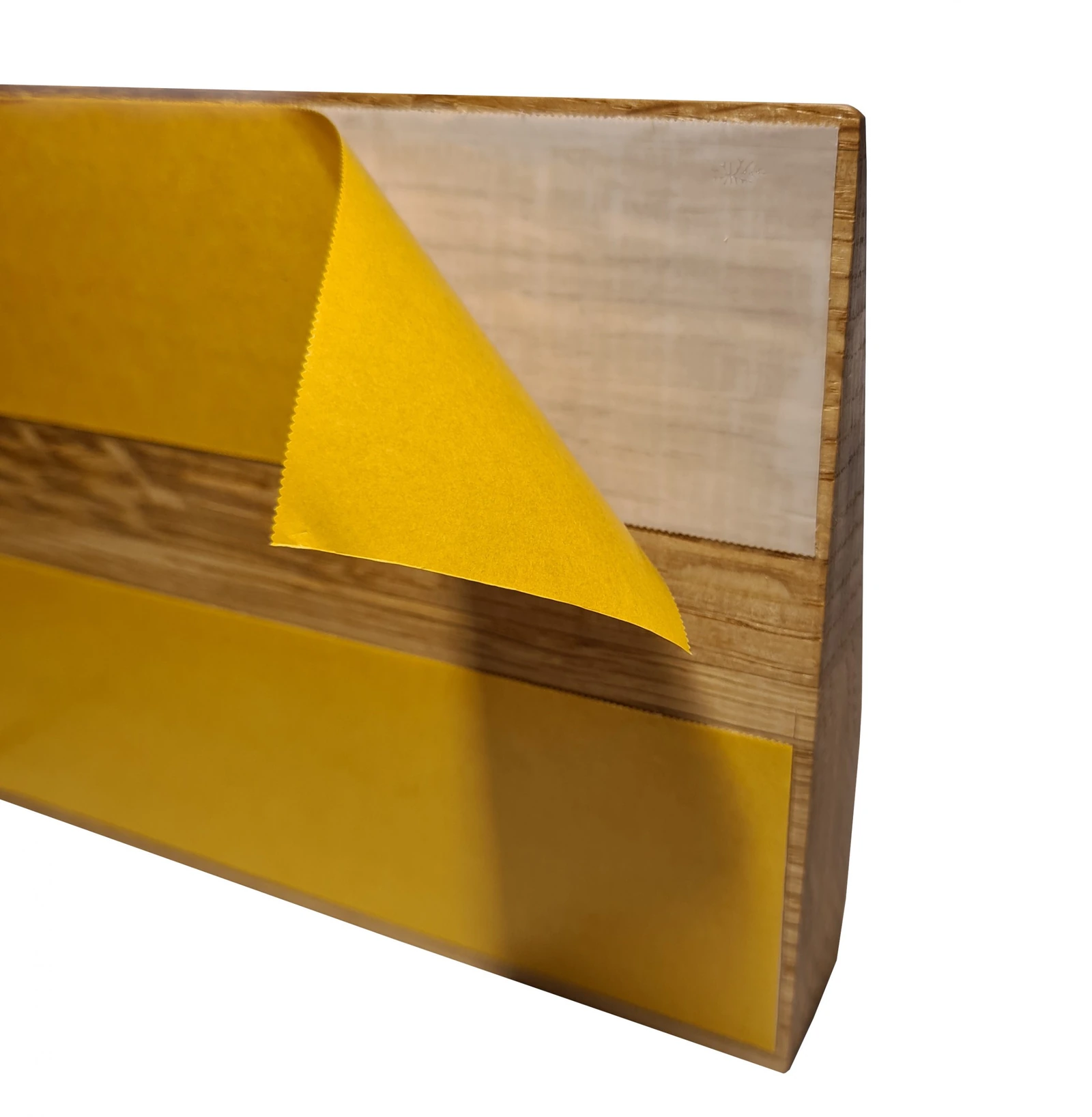 Dessous d’une rampe en bois avec bande de montage et film de protection jaune retiré